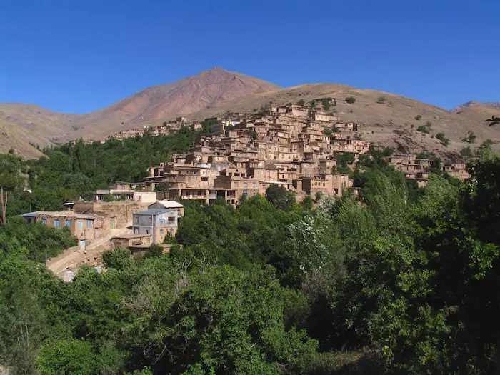 نمایی از خانه های پلکانی روستای دیزباد در دل کوه و پوشیده از درخت 54163215632632