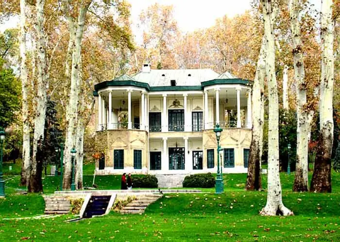 نمایی از محوطه سرسبز و درختان تنومند و خونه عمارتی باغ ملک آباد مشهد 635341563416314