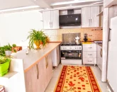 آشپزخانه با کابینت های چوبی، یخچال، هود و گل های خانه ویلایی در قوچان 4588654