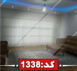 اتاق پذیرایی فرش شده و کفپوش پارکت با مبلمان قهوه ای رنگ آپارتمان در تایباد 4685478