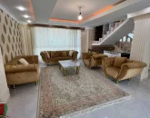 اتاق پذیرایی فرش شده با مبلمان کرمی و پله های همکف ویلا در مشهد 451844