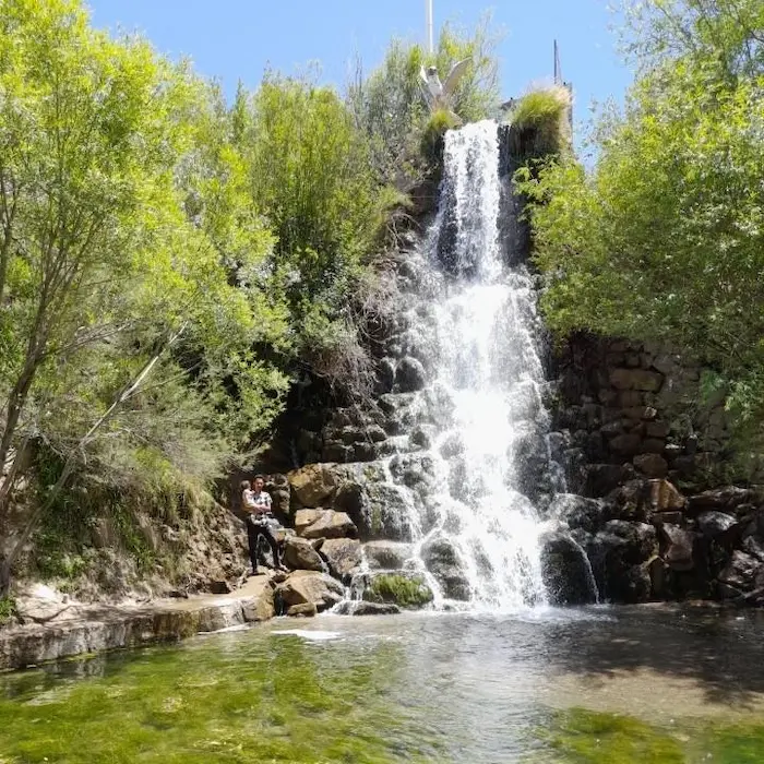 آبشار پرتلاطم میان صخره های سنگی میان پوشش گیاهی سرسبز در گناباد 586451
