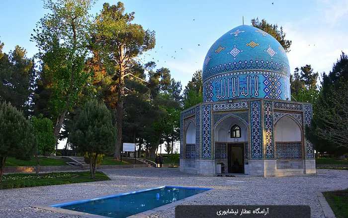 نمای بیرونی آرامگاه گنبدی شکل عطار نیشابوری در کنار درختان سرسبز و حوضچه آبی کوچک در نیشابور 2156156