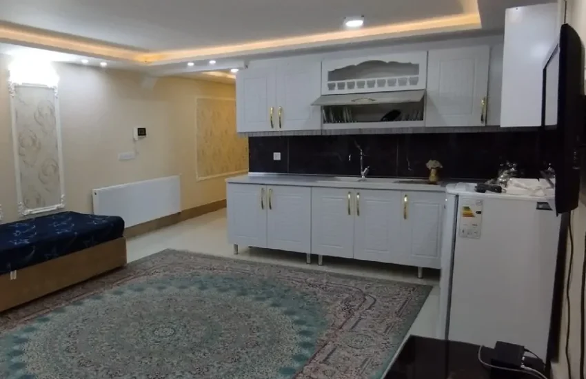 آشپزخانه با کابینت های سفید و اتاق پذیرایی خانه ویلایی در مشهد 48578435943