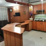 آشپزخانه با کابینت های چوبی و اتاق پذیرای واحد آپارتمان در مشهد 85769874458