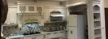 کابینت های کلاسیک و سقف نور پردازی شده با نور زرد آشپزخانه آپارتمان در تربت حیدریه