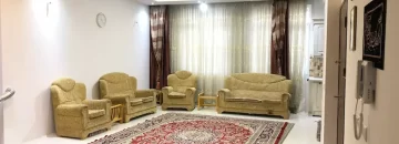 مبلمان زرد رنگ و سقف نور پردازی شده با نور زرد سالن نشیمن آپارتمان در تربت حیدریه
